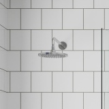 Product lifestyle image of Britton Hoxton 2.0 Chrome Shower Head and Arm against white brick tiled wall HOX300C